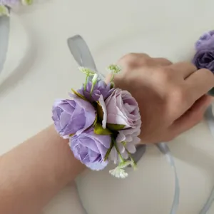 Vista dettagliata di un corsetto da polso con rosa artificiale viola per damigelle.