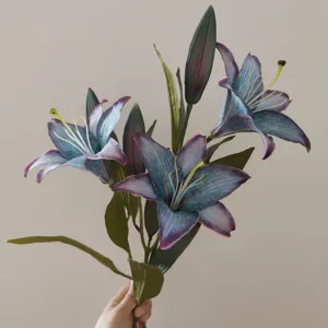 Detail view of artificial retro lily flower branch with gradient petals and realistic green leaves.