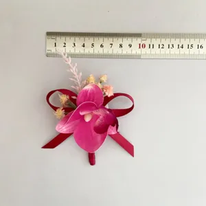 Bottoniera di orchidea artificiale con nastro rosso, perfetto accessorio da sposo.