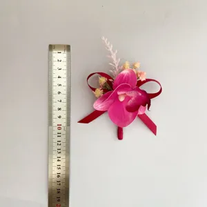 Bottoniera orchidea magenta con nastro rosso per abito da sposo e fotografia aziendale.