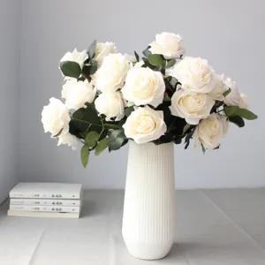 Bouquet di rose bianche artificiali in vaso di ceramica bianca per decorazione domestica.