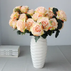 Bouquet di rose francesi artificiali in vaso di ceramica bianca, elegante decorazione floreale.