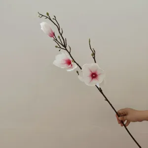 Primo piano di un ramo di magnolia artificiale, fiore di seta realistico per arredamento.