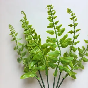Primer plano de hojas de helecho verde artificial, ramas de plantas de plástico para arreglos.