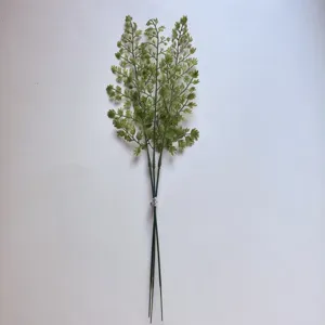 Rama de planta verde artificial en detalle para decoración del hogar y arreglos florales.