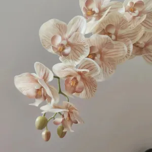 Primo piano dettagliato di fiori di orchidea phalaenopsis artificiali con petali realistici.