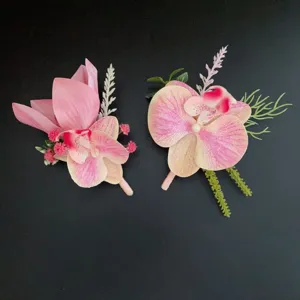 Detailed view of artificial pink orchid boutonniere flowers for weddings and business events.
