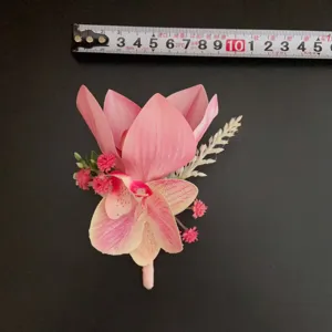 Detail shot of the pink phalaenopsis boutonniere, showing floral craftsmanship and tape measure.