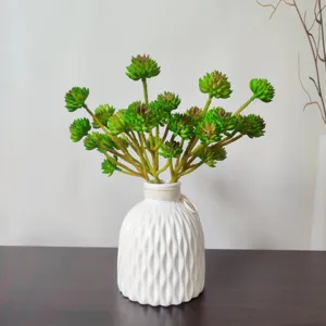 Dettaglio di pianta succulenta artificiale con foglie verdi realistiche in vaso di ceramica bianca.