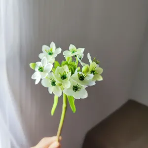 Close-up detail of artificial velvet flower bouquet with white star blossoms and green centers.