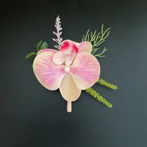 Artificial orchid boutonniere pink flower corsage for wedding groom suit tuxedo decoration detail shot