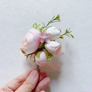 Artificial pink boutonniere wedding groom groomsman corsage detail fabric flower decor.