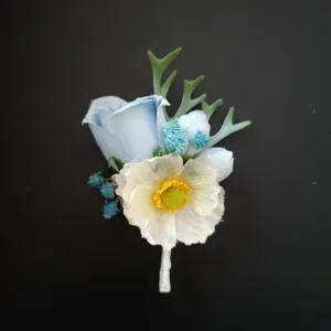 Close-up detail of blue and white artificial groom boutonniere lapel flower for wedding event.