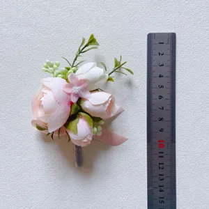 Light pink artificial flower boutonnière corsage for wedding groomsmen and guests.