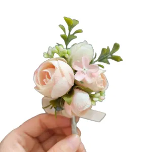Artificial pink rose wedding boutonniere for groomsmen, elegant floral lapel pin decor.