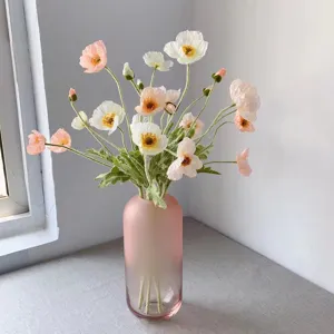 Detailed view of flocked artificial Iceland poppy flowers bouquet in pink glass vase for home decor