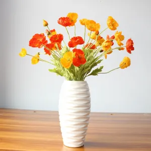 Artificial Iceland poppy bouquet close-up, vibrant orange and yellow silk flowers in white vase.