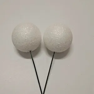 Detalle de las bolas de decoración de pasteles blancas brillantes con tallos negros.