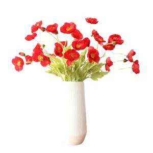 Artificial red poppy flowers bouquet in a white ribbed vase for home decor floral display.