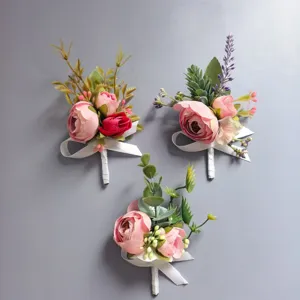 Vista detallada de ramilletes de rosas artificiales rosas hechas a mano con cintas blancas.