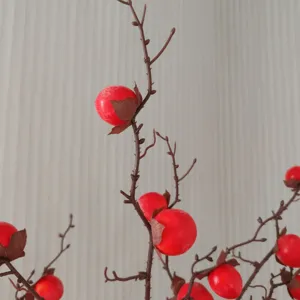 Détail de branche de mini kaki artificiel pour la décoration intérieure et l'arrangement floral.