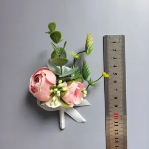 Botonier de flores artificiales rosas para boda de novio y novia, vista detallada con regla.