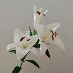 Detailed close-up of premium artificial white lily flower, realistic touch and natural green leaves.