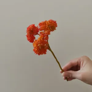 Primo piano dettagliato del ramo di fiori succulenti artificiali arancioni per artigianato fai da te.