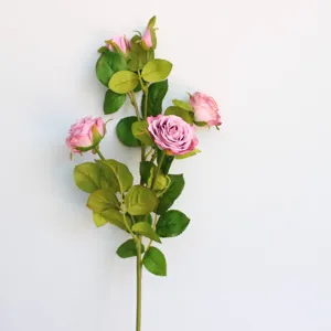 Detailaufnahme künstlicher Rosenzweig mit rosa Blüten und grünen Blättern für die Heimdekoration.