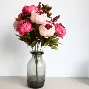 Close up view of artificial peony flower bouquet details in glass vase for home decor