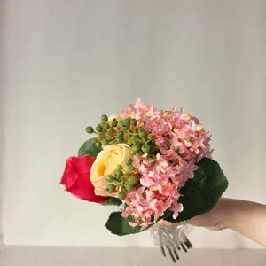 Handmade artificial flower bouquet with mixed roses and hydrangeas for home wedding decor.