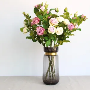 Künstlicher Rosenblumenstrauß mit stilvoller Glasvase für elegante Heimdekoration Requisite.