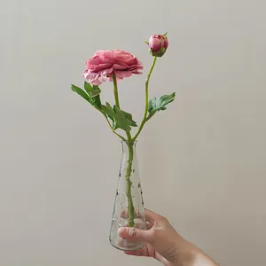 Artificial camellia flower with glass vase detail shot for home decor photography.