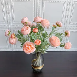 Primo piano di fiori di ranuncolo artificiali in un vaso di vetro per decorazione domestica.