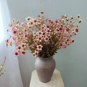 Detail view of artificial chamomile flowers in a vase, ideal for home decor styling.