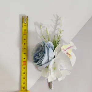 Gedetailleerd overzicht van de blauw-witte kunstbloem corsage met meetlint als referentie.