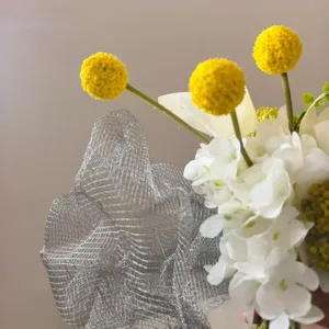 Gros plan d'un bouquet de fleurs artificielles luxueux avec des boules jaunes et hortensias blancs.