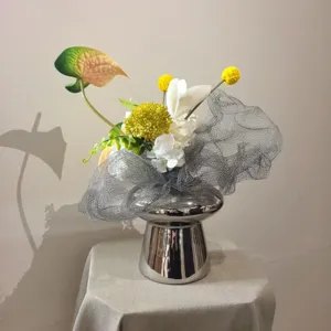 Bouquet de fleurs artificielles de luxe moderne en vase argenté, idéal pour décoration et photo.