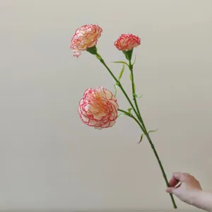 Detailed close-up shot of artificial carnation flower heads with delicate petals for decor.