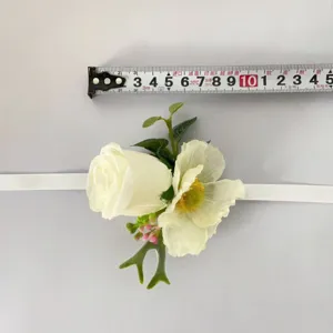 Vue détaillée de la fleur de poignet en rose artificielle blanche avec ruban pour la photographie.