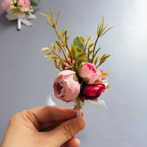 Vista de primer plano detallada de boutonnière de rosa artificial con cinta rosa y hojas.