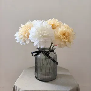 Artificial dahlia flowers in glass vase with ribbon home decor floral arrangement.
