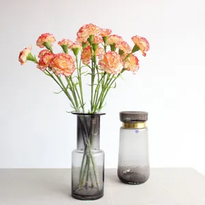 Artificial carnations silk flower bouquet in glass vase for home decor and wedding detail.