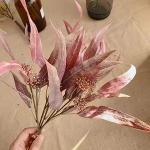 Gros plan détail du bouquet de fleurs d'eucalyptus artificiel avec de longues feuilles roses.