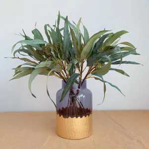 Bouquet de fleurs d'eucalyptus artificiel avec baies dans un vase en verre violet déco.