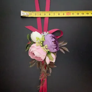 Corsage de flores artificiales flor de muñeca boda con rosas rosa violeta y cinta roja.