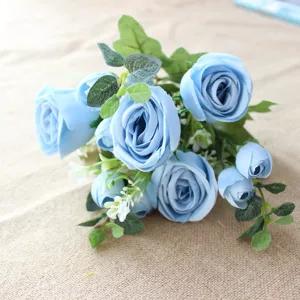 Close-up detail shot of artificial blue rose bouquet with eucalyptus leaves and floral decor.