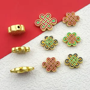 Close-up details of gold alloy Chinese knot spacer beads with colorful enamel for DIY crafts.
