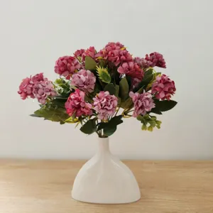 Detailansicht des künstlichen Blumenstraußes in einer eleganten weißen Keramikvase für die Dekoration.