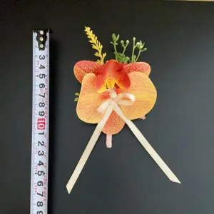 Vue de détail de la boutonnière en orchidée artificielle avec un délicat nœud ruban rose élégant.